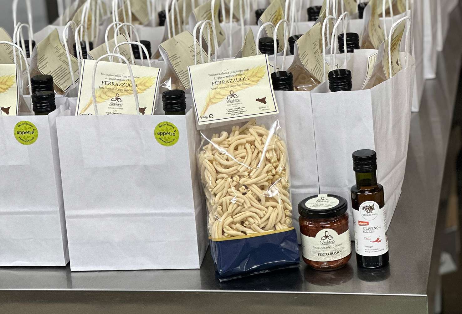 Weiße Geschenktüten mit Pasta, Olivenöl und Aufstrichen